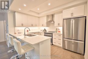 London North (North R) condo for rent - A modern kitchen with white cabinets and stainless steel appliances.