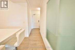 London North (North R) condo for rent - A hallway with a table and chairs on the left and a door at the end.
