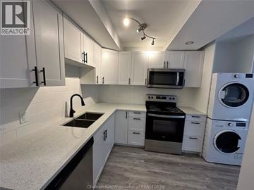 Chatham apartment for rent - A kitchen with white cabinets and a black countertop.