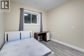 Windsor apartment for rent - A bedroom with a bed, desk, and window.