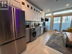 Windsor condo for rent - A kitchen with a refrigerator, washing machine, and a dining table.