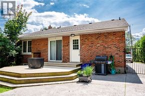 Burlington apartment for rent - A red brick house with a white door and a grey trash bin.