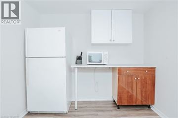 Burlington apartment for rent - A white refrigerator is in a kitchen next to a wooden cabinet.