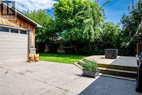 Burlington apartment for rent - A backyard with a wooden deck, a garage, and a tree.