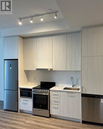 Vaughan (Vaughan Corporate Centre) condo for rent - A modern kitchen with white cabinets and stainless steel appliances.