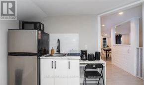 Hamilton (Strathcona) duplex for rent - A kitchen with a refrigerator, microwave, and sink.