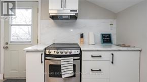 Hamilton (Strathcona) duplex for rent - A white kitchen with a black stove top oven.