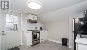 Hamilton (Strathcona) duplex for rent - A kitchen with a white oven and a black fridge.
