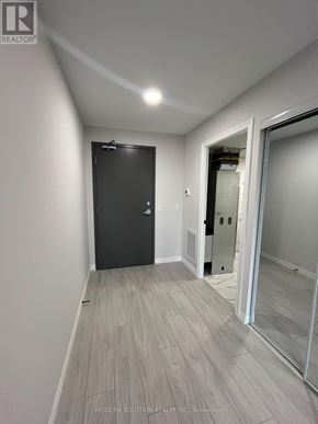 Kitchener condo for rent - A room with a black door and a wooden floor.