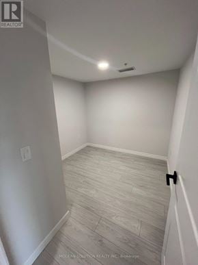 Kitchener condo for rent - A room with a wooden floor and white walls.