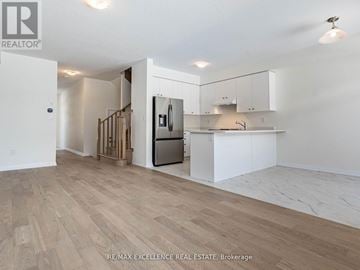 Haldimand townhouse for rent - A spacious kitchen with white cabinets and a wooden floor.