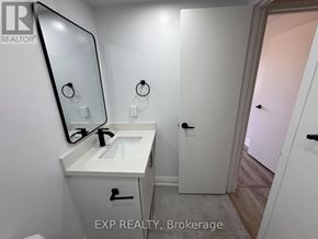 Niagara Falls (Downtown) apartment for rent - A bathroom with a sink, mirror, and a door.