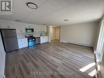 Niagara Falls (Downtown) apartment for rent - A kitchen with a refrigerator, oven, and microwave.