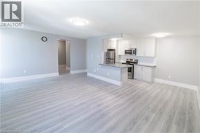Niagara Falls apartment for rent - A spacious living room with a kitchenette in the background.