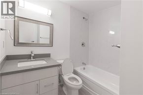 Niagara Falls apartment for rent - A white toilet is in a bathroom with a sink and mirror.