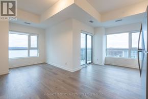 Barrie (Little Lake) condo for rent - A spacious room with wooden floors and large windows.