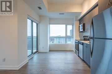 Barrie (Little Lake) condo for rent - A kitchen with a refrigerator on the right side.