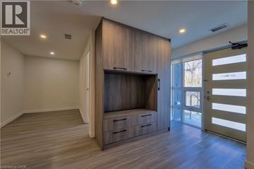 Hamilton townhouse for rent - A living room with a television and wooden cabinets.