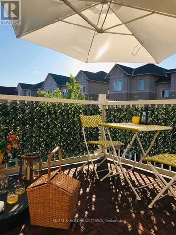 Ottawa townhouse for rent - A patio with a table and chairs under an umbrella.