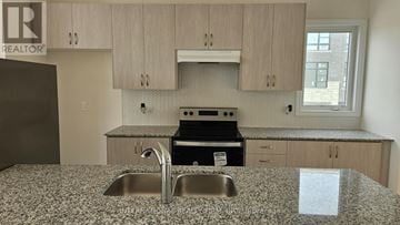 Vaughan (Kleinburg) townhouse for rent - A kitchen with a granite countertop and a sink.