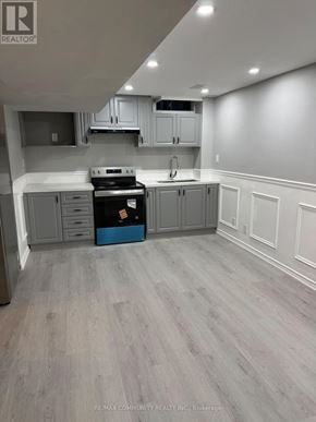 Whitchurch-Stouffville (Stouffville) apartment for rent - A kitchen with grey cabinets and a black stove top oven.