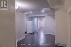 Brampton (Fletcher's Meadow) apartment for rent - A white room with a fridge and a doorway leading to another room.