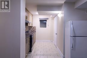 Brampton (Fletcher's Meadow) apartment for rent - A kitchen with a refrigerator on the right and a window in the middle of the room.