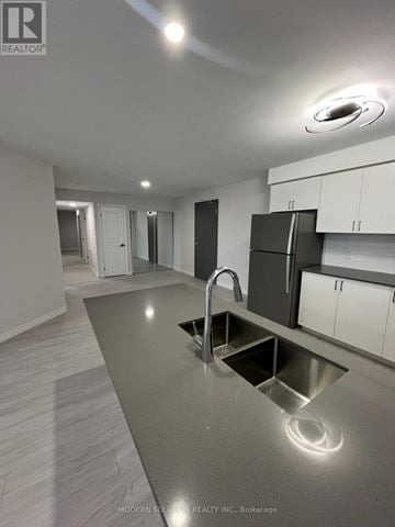 Kitchener condo for rent - A modern kitchen with a sink and cabinets.