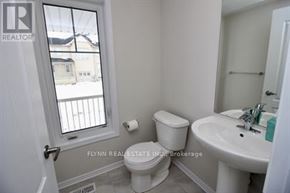 Haldimand townhouse for rent - A white toilet sits next to a sink in a small bathroom.