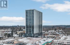 Kitchener condo for rent - A tall building with many windows is the focal point of the image.