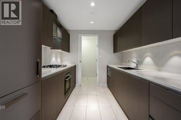 Richmond apartment for rent - A modern kitchen with dark brown cabinets and white countertops.