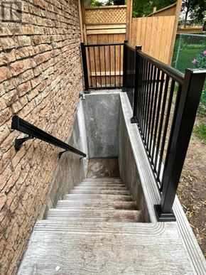 Pickering (Liverpool) apartment for rent - A set of stairs with a black railing and a brick wall on one side.