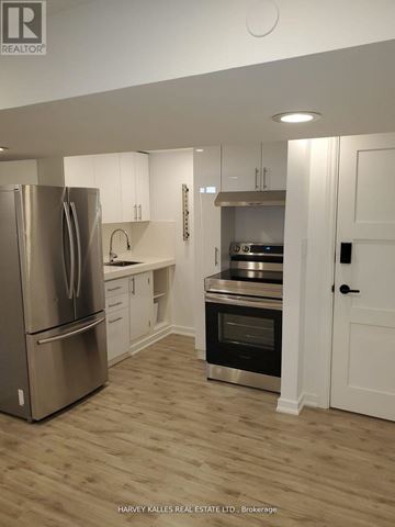 Newmarket (Central Newmarket) apartment for rent - A modern kitchen with a stainless steel refrigerator and wooden flooring.
