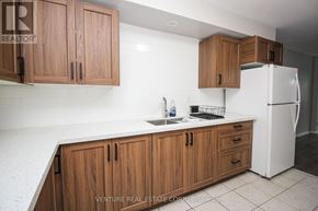 Toronto (Kingsway South) multi-family for rent - A kitchen with wooden cabinets and a white refrigerator.