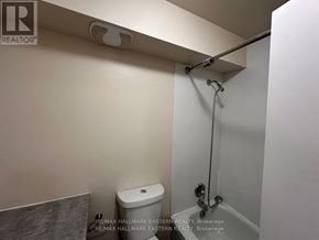 Peterborough (Town Ward 3) apartment for rent - A white toilet in a small bathroom with a shower head above it.