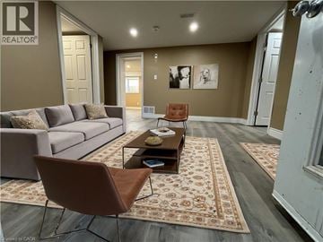 Kitchener apartment for rent - A living room with a brown chair and a grey couch.
