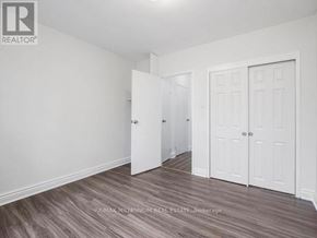 Kitchener condo for rent - A room with white walls and a wooden floor with a brokerage logo.