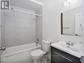 Kitchener condo for rent - A white bathroom with a toilet, sink, and shower.