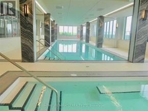 Toronto (Mimico) condo for rent - A swimming pool inside a building with a glass wall and a sign that says "REALTOR".