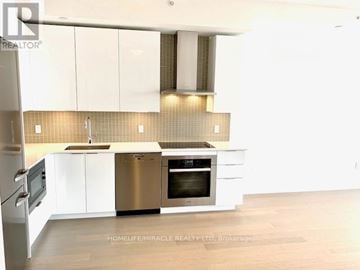 Toronto (Mimico) condo for rent - A modern kitchen with white cabinets and a stainless steel oven.