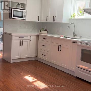 Mississauga (Erindale) apartment for rent - A kitchen with white cabinets and a wooden floor.