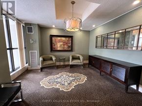 Toronto (Englemount-Lawrence) condo for rent - A hallway with a black door and a chandelier.