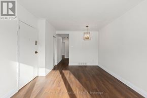 Toronto (Birchcliffe-Cliffside) triplex for rent - A long hallway with a light on the wall and a door on the left.
