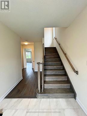 Welland (Dain City) apartment for rent - A staircase with wooden steps and a metal handrail.