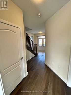 Welland (Dain City) apartment for rent - A hallway with a white door and a black staircase.