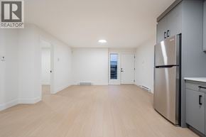 Burnaby apartment for rent - A spacious kitchen with a refrigerator and wooden flooring.