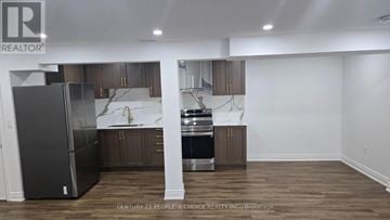 Haldimand apartment for rent - A kitchen with a refrigerator, sink, and cabinets.