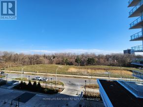Toronto (Parkwoods-Donalda) condo for rent - A view from a high-rise building looking down at a parking lot and a grassy area.