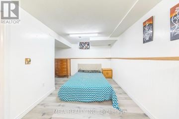 Toronto (Milliken) townhouse for rent - A bedroom with a bed covered in a blue and white patterned bedspread.
