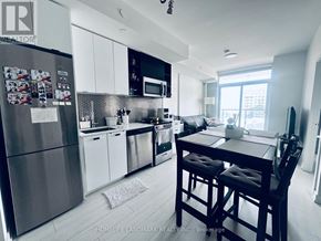 Toronto (York University Heights) condo for rent - A kitchen with a refrigerator, sink, and dining table.